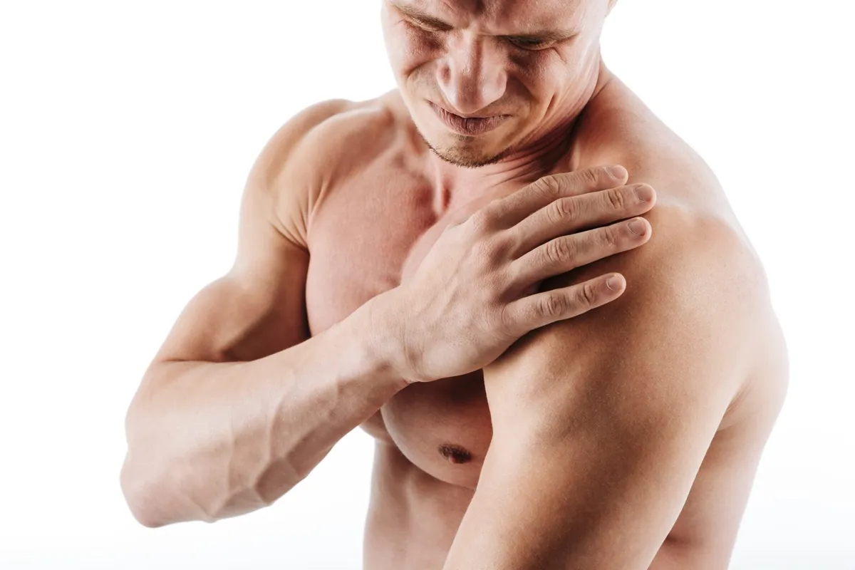 Athlete holding his shoulder in pain during training